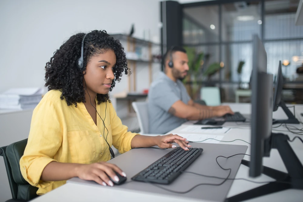 Customer support specialists working at computers with headsets