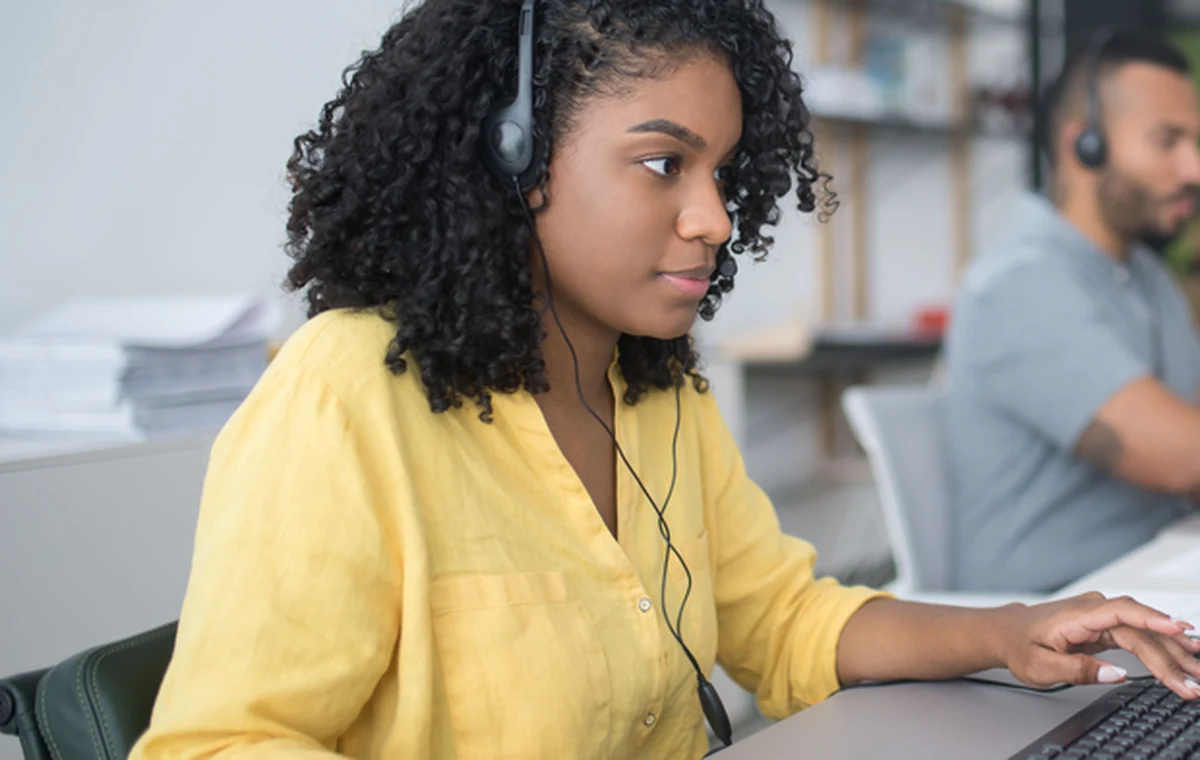 Customer support specialist using a headset at a computer